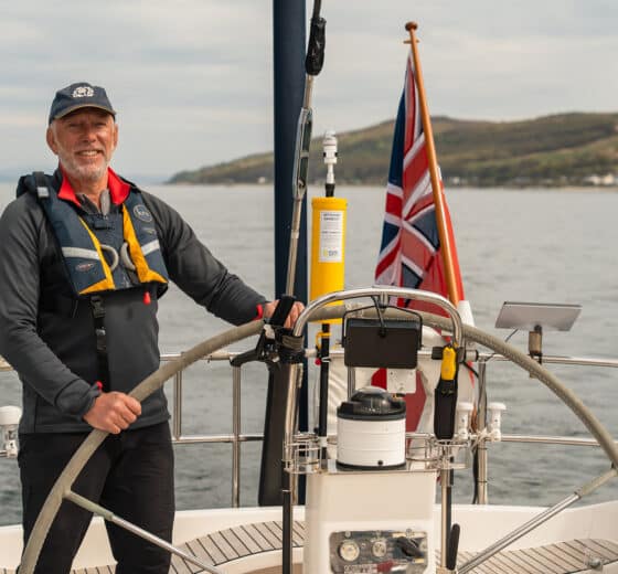 Noonmark VI guest onboard at helm male solo sailor traveller sailing