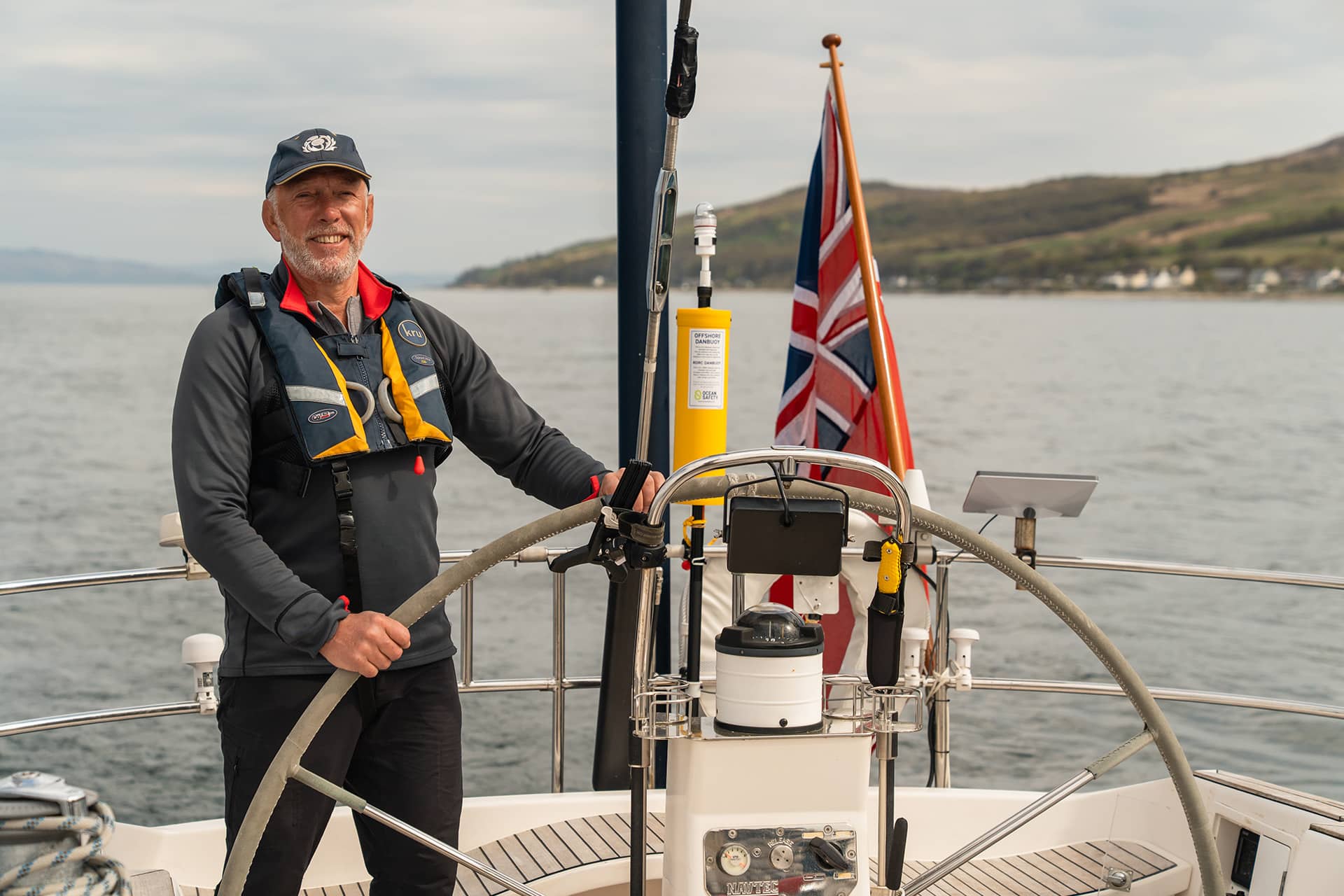 Noonmark VI guest onboard at helm male solo sailor traveller sailing