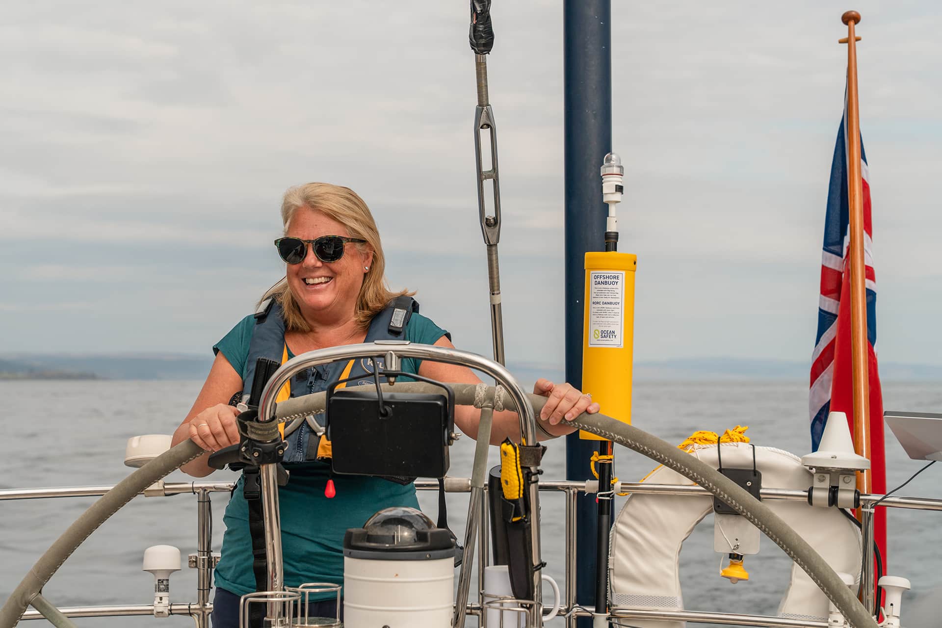 Noonmark VI guest onboard at helm solo female sailor in Scotland, Hebrides sailing