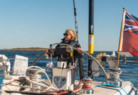Noonmark VI yacht guest at helm solo female sailor JO