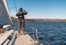 Noonmark VI yacht guest wildlife watching on deck in the Hebrides, Scotland