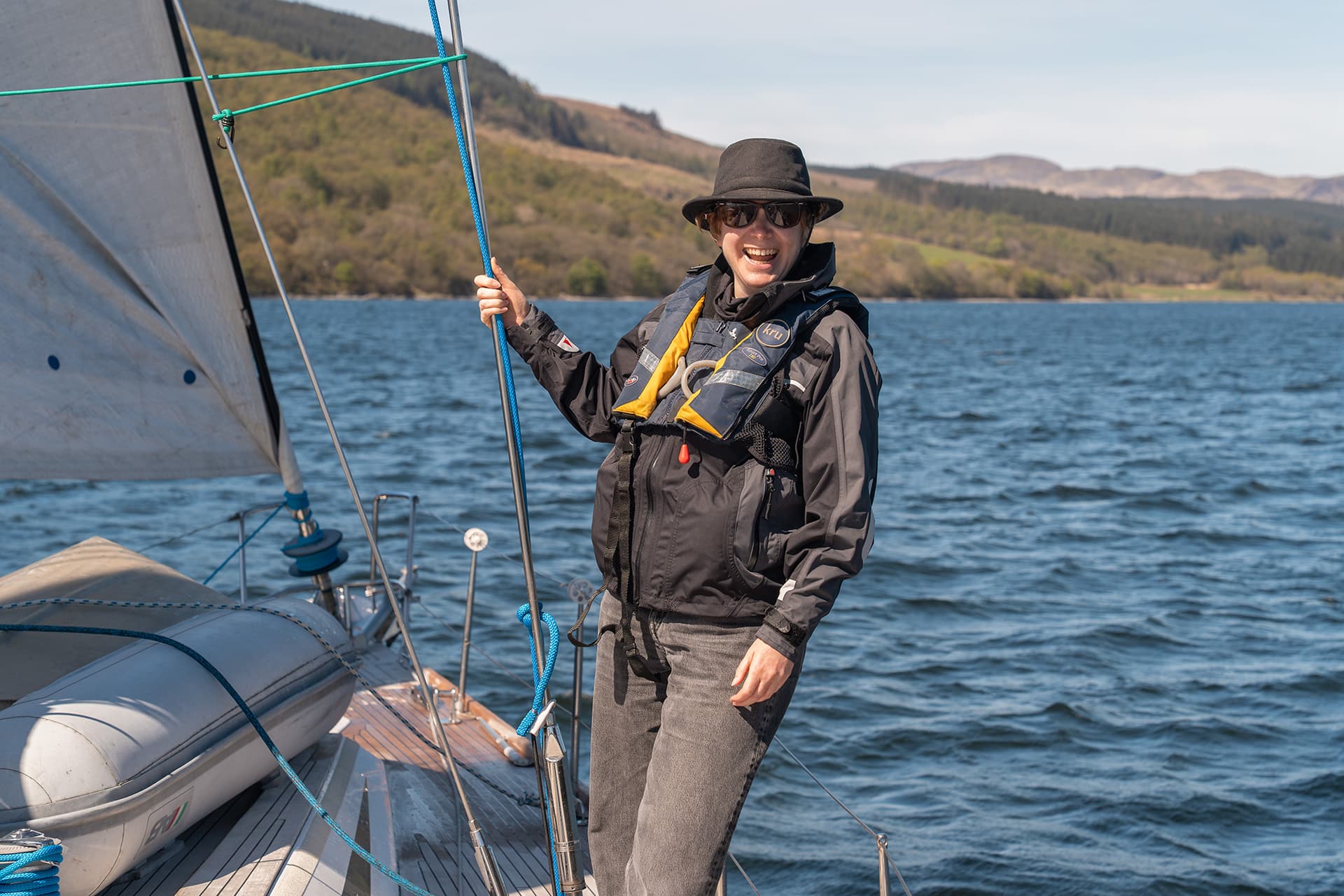 Noonmark VI yacht solo female guest on deck of yacht underway sailing in Scotland