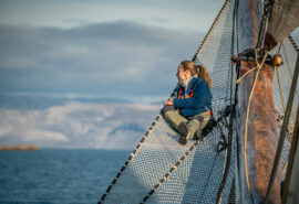 Noorderlicht guest on bowsprit of tall ship Svalbard summer
