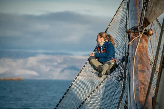Noorderlicht guest on bowsprit of tall ship Svalbard summer
