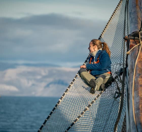 Noorderlicht guest on bowsprit of tall ship Svalbard summer