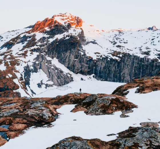 Person hiking in snowy Lofoten islands Norway