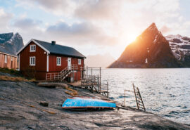 Red cabin on shoreline in Lofoten islands