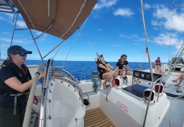 Sea Dragon female guests solo sailors underway on deck at helm