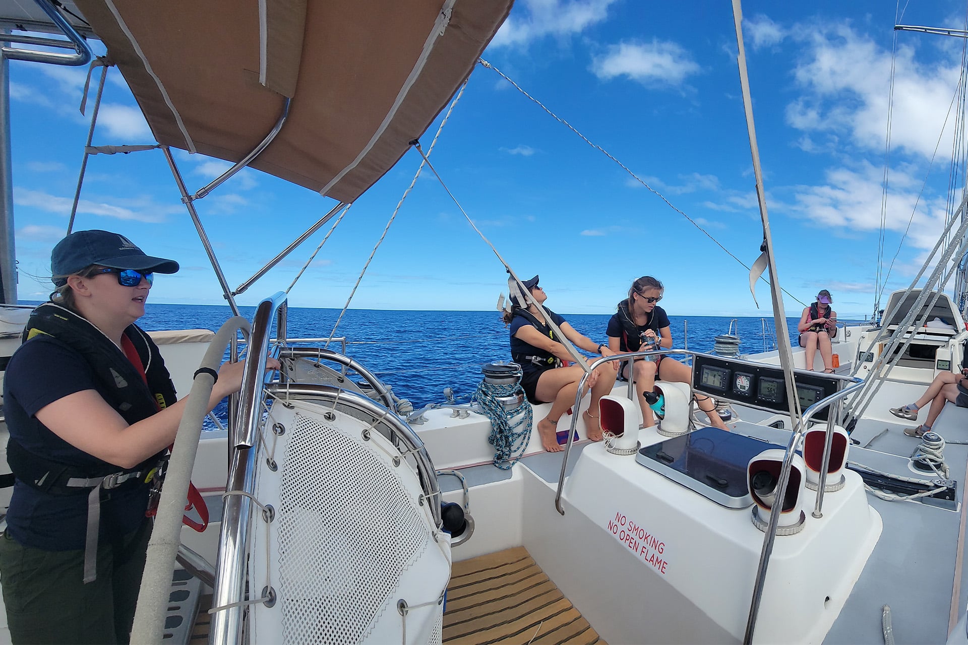 Sea Dragon female guests solo sailors underway on deck at helm