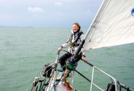 Sea Dragon guest on bowsprit solo female sailor
