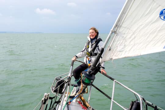 Sea Dragon guest on bowsprit solo female sailor