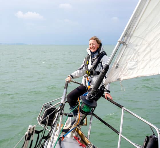 Sea Dragon guest on bowsprit solo female sailor