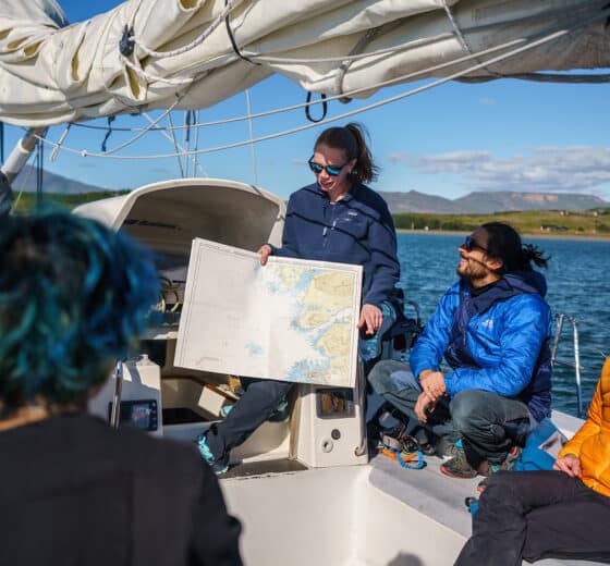 Sea Dragon guests on deck looking at map navigation underway sailing