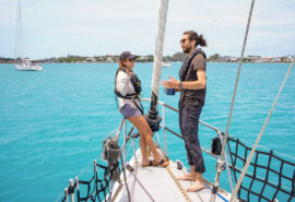 Sea Dragon guests talking on bowsprit sunshine seas