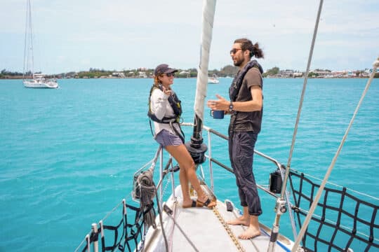 Sea Dragon guests talking on bowsprit sunshine seas