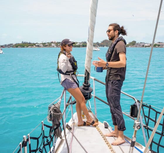 Sea Dragon guests talking on bowsprit sunshine seas