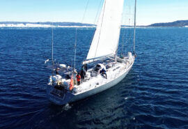 Sea Dragon sailing yacht underway from stern in Arctic Circle Greenland -