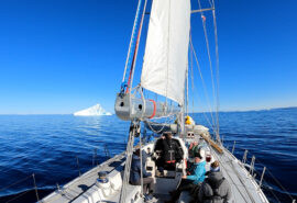 Sea dragon yacht sailing underway view on deck in Greenland, Arctic waters, Iceberg
