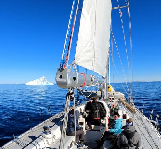 Sea dragon yacht sailing underway view on deck in Greenland, Arctic waters, Iceberg