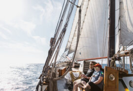 Twister guests relaxing on deck of schooner in sunshine underway