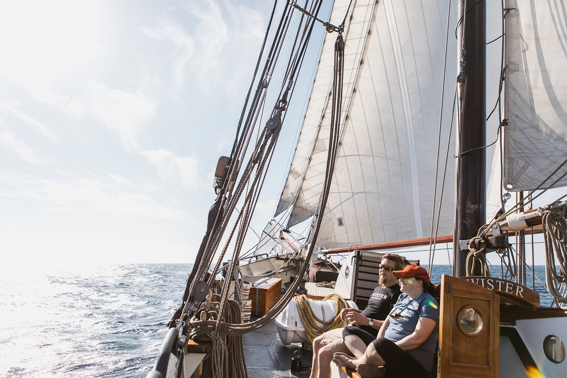 Twister guests relaxing on deck of schooner in sunshine underway