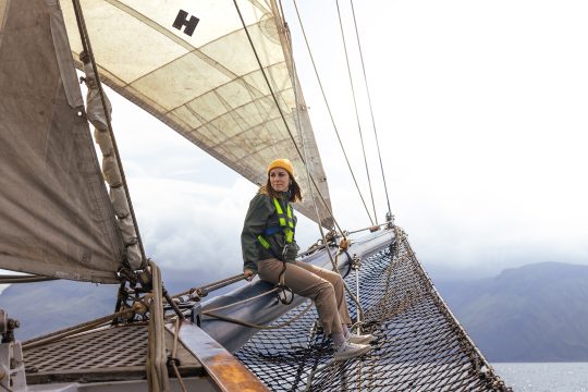 Woman on bowsprit of Blue Clipper