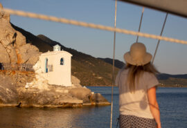 Zorba yacht guest on deck admiring view of Saronic islands Greece