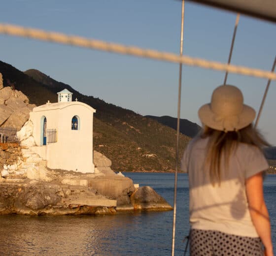 Zorba yacht guest on deck admiring view of Saronic islands Greece