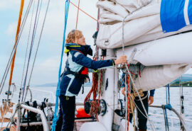 Zuza expedition yacht female solo sailor guest onboard tying ropes