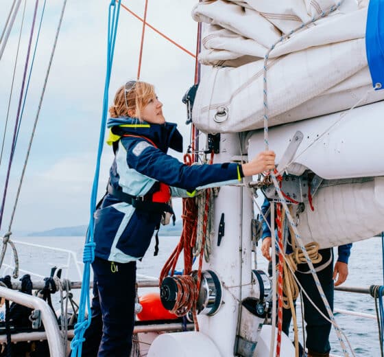 Zuza expedition yacht female solo sailor guest onboard tying ropes