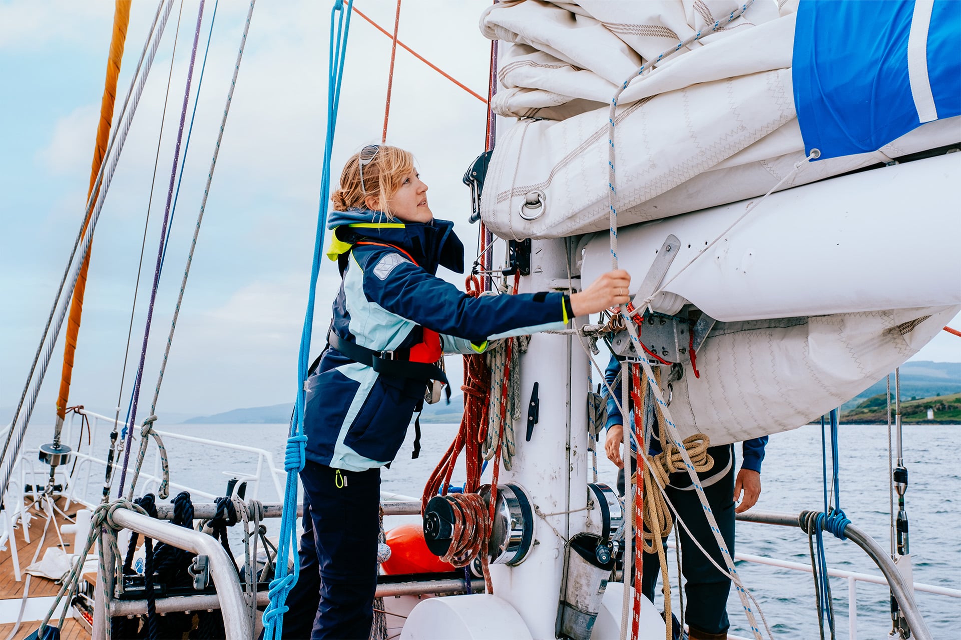 Zuza expedition yacht female solo sailor guest onboard tying ropes