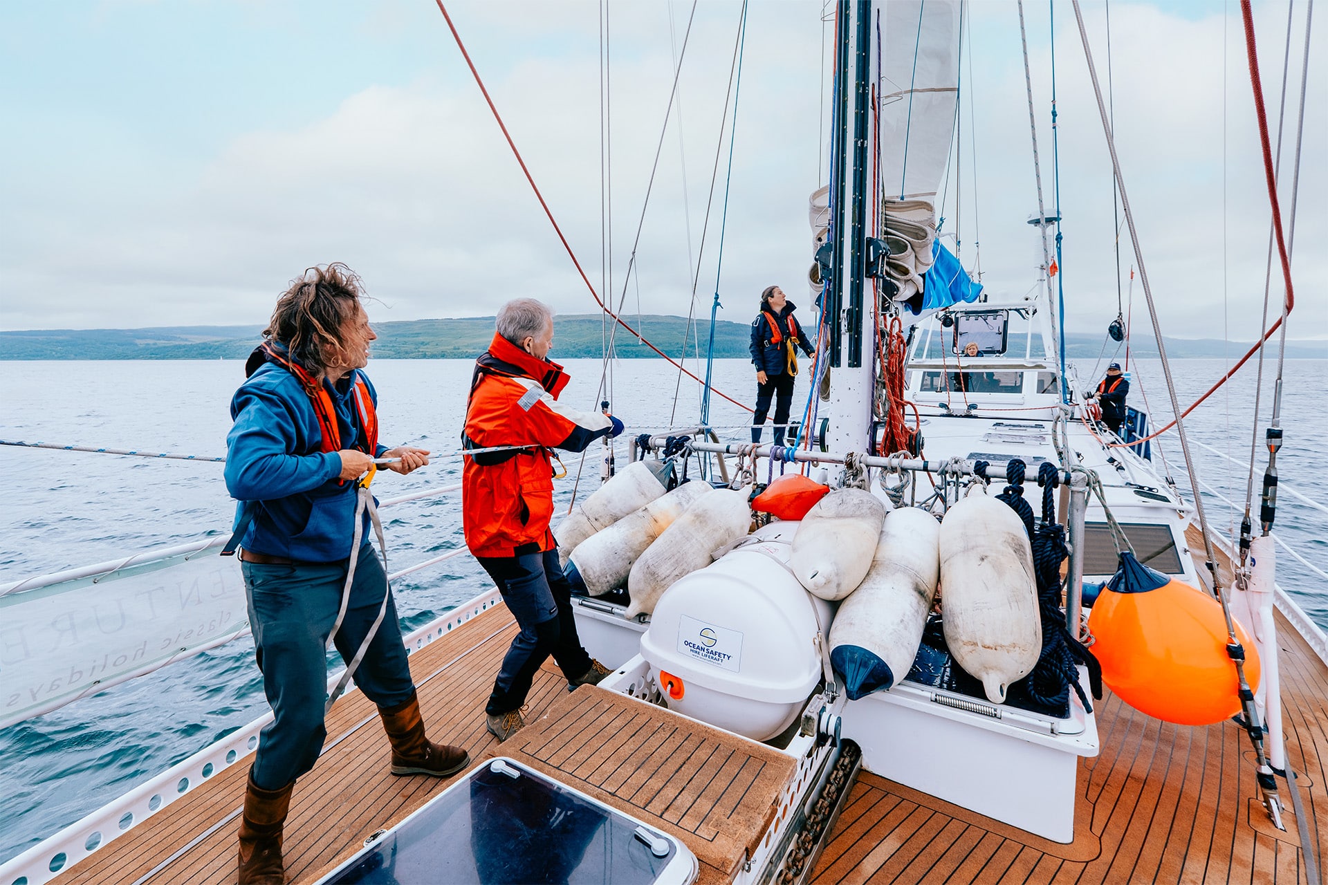 Zuza expedition yacht guests onboard sailing pulling ropes raising sail
